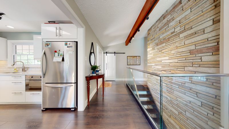 Hallway with stone feature wall and glass railing