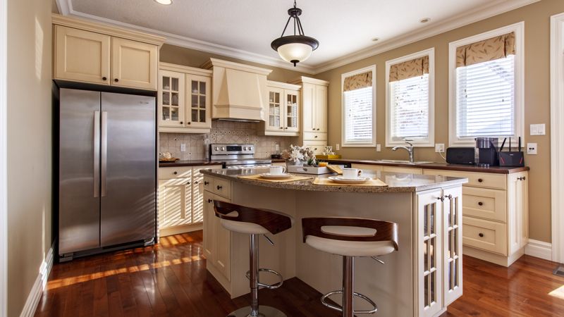 HDR interior photo of a kitchen with granite island and stools