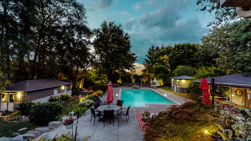 Twilight photo of a backyard pool and patio